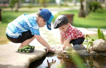 Foto, kleine Kinder spielen am Teich