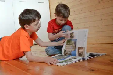 Foto, zwei kleine Kinder lesen ein Buch